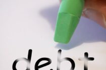 debt being erased on a piece of paper by ahand holding a pencil