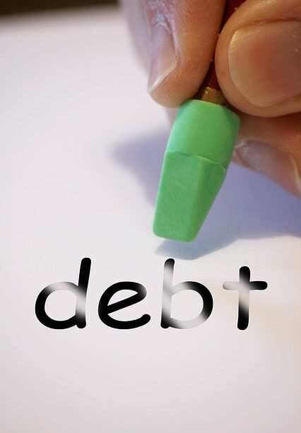 debt being erased on a piece of paper by ahand holding a pencil